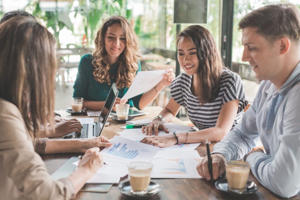 Menschen beim Meeting mit Dokumenten im Café.
